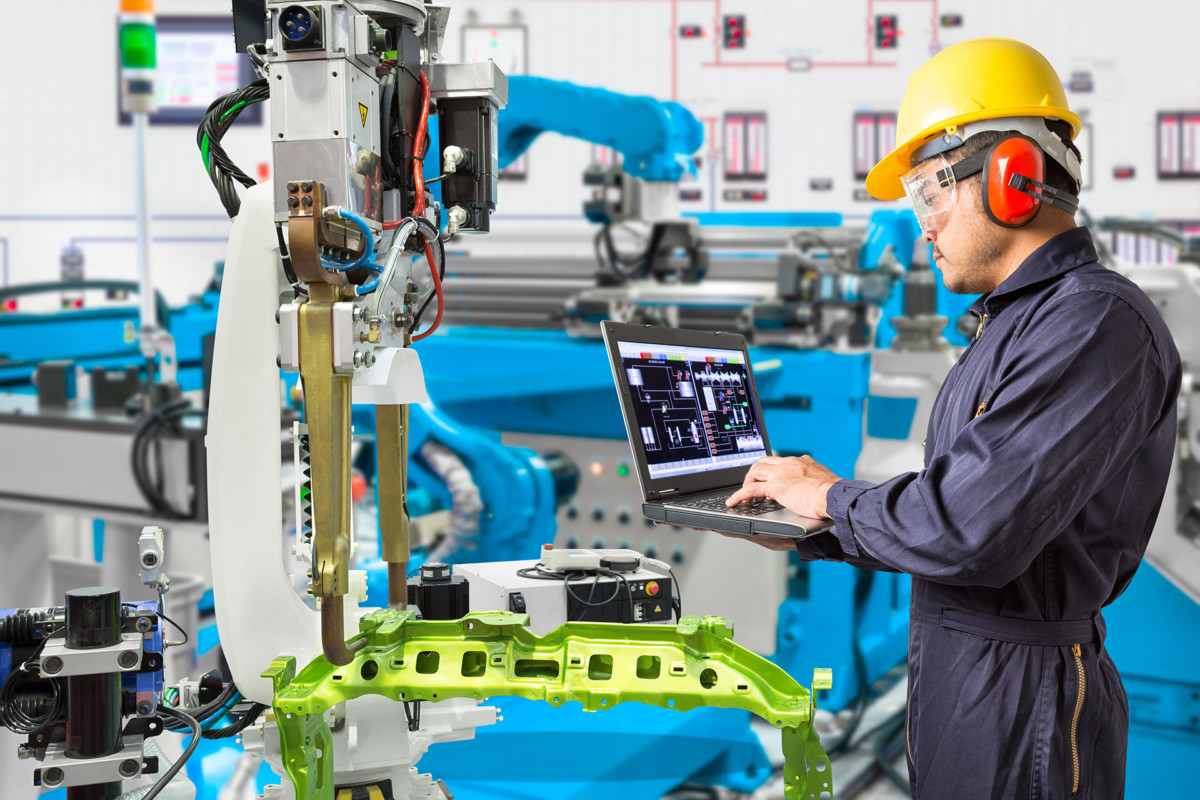 Engineer using laptop in factory
